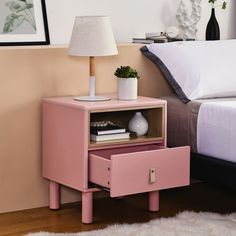 a pink nightstand next to a bed in a bedroom