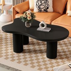 a living room with an orange couch and black coffee table