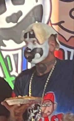 a man wearing a white mask and holding a pizza