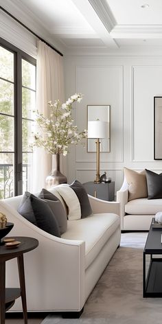 a living room filled with white furniture and lots of pillows on top of it's couches