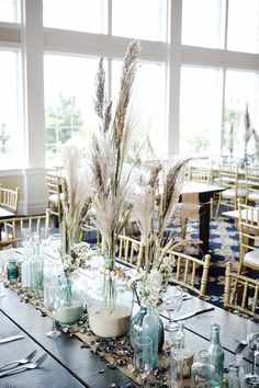 there are many vases with flowers in them on the table at this wedding reception