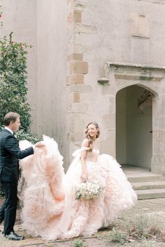 a bride and groom standing in front of an old building