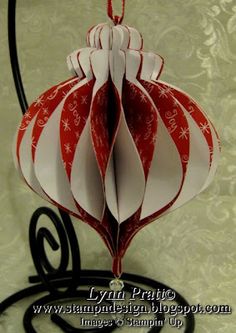 a red and white ornament hanging from a black stand