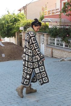 a woman is walking down the street wearing an oversize coat