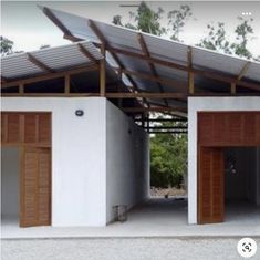 two garages with wooden doors are shown in this image, and one is empty