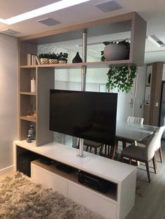 a flat screen tv sitting on top of a white entertainment center in a living room