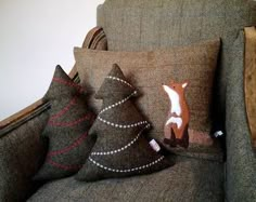 three decorative pillows sitting on top of a couch next to a pillow that is shaped like a deer