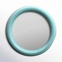 a round mirror on the wall with a light blue ring around it's edge