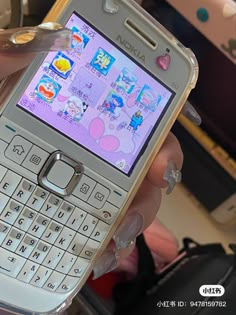 a person holding a cell phone in their hand with stickers on the display screen