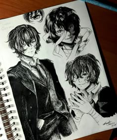 an image of some anime character sketches on a notebook with pen and paper next to it