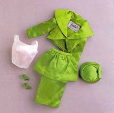 the doll is wearing a green outfit with white bra and shoes for her to wear