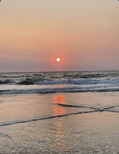 the sun is setting over the ocean with waves