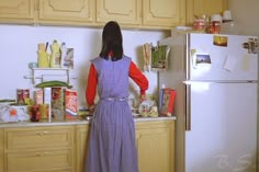 a woman standing in front of a refrigerator