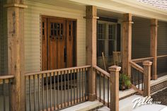 the front porch of a house with wooden railings and chairs on the steps next to it