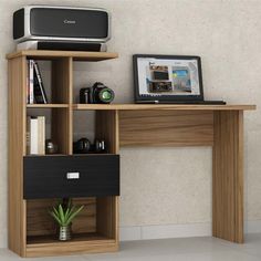 a laptop computer sitting on top of a wooden desk next to a shelf with books