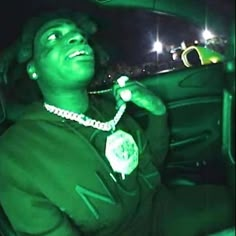 a man sitting in the back seat of a car with green light on his face