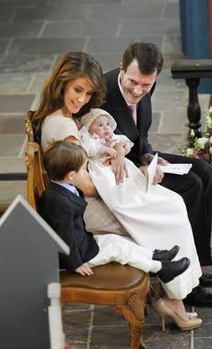 the duke and princess of cambridge with their son prince george, who is wearing a suit and tie