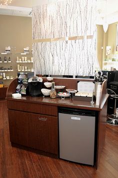 a coffee shop with wooden flooring and counter top space for items on the shelves