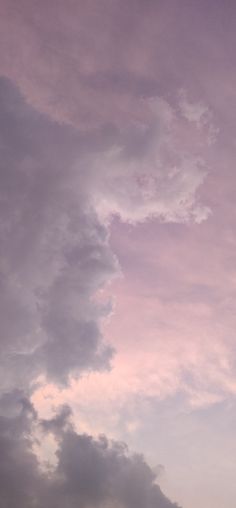 an airplane is flying through the cloudy sky