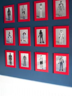 a blue wall with red frames and pictures of people in different outfits on it's sides