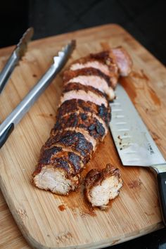 there is a knife and some meat on the cutting board with it's end cut off