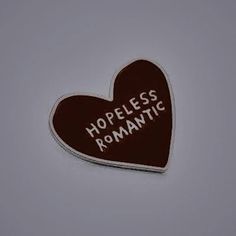 a heart shaped sticker with the words hopeless romantic written on it