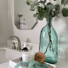 a vase with flowers in it sitting on a bathroom counter