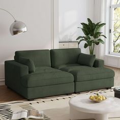 a living room with two green couches and a coffee table in front of a large window