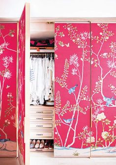 an open closet with pink wallpaper and floral designs on the doors is shown in this image