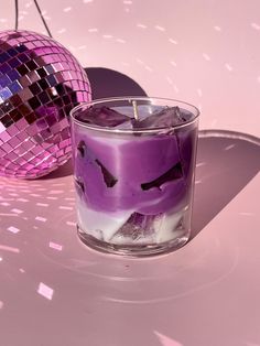 a purple candle sitting next to a disco ball