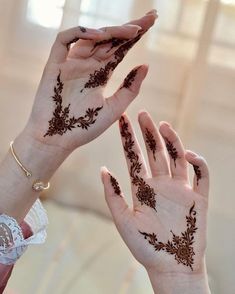 two hands with henna designs on them are reaching up to touch each other's palms