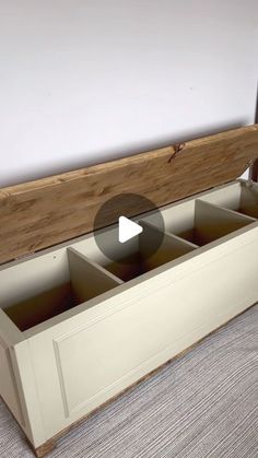 an empty storage box sitting on top of a carpeted floor next to a white wall