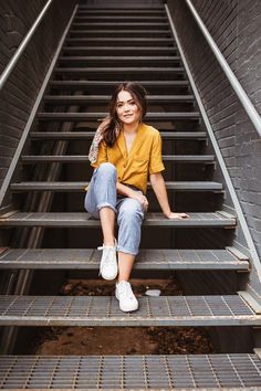 a woman is sitting on the steps outside