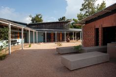 an outdoor courtyard with concrete benches and brick buildings