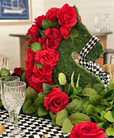 the table is decorated with red roses and greenery for an anniversary party or special occasion