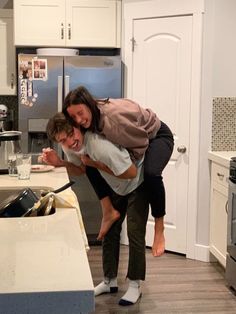 two people in a kitchen hugging each other