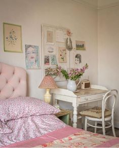 a bedroom with a bed, desk and pictures on the wall