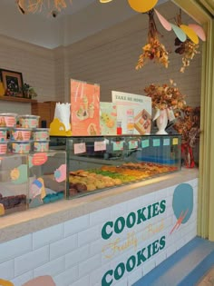 there is a display case in the bakery with cookies on it's counter and pastries hanging from the ceiling