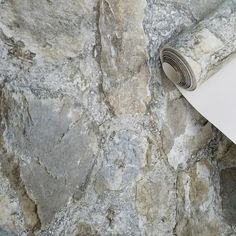 a roll of white paper sitting on top of a stone wall