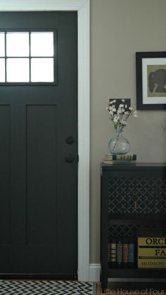 a black and white checkered floor in front of a door with two vases on it