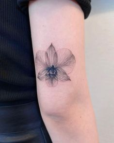 a black and white flower tattoo on the arm