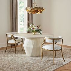 a dining room table with two chairs and a chandelier hanging from the ceiling