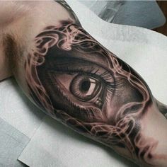 a man's arm with an eye tattoo on it