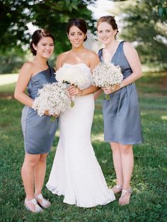 three bridesmaids pose for a photo in the grass with their bouquets on