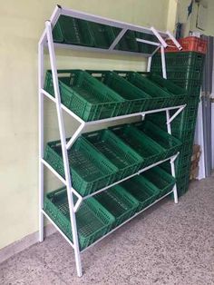 several green baskets are stacked on top of each other in a storage area at the end of a hallway