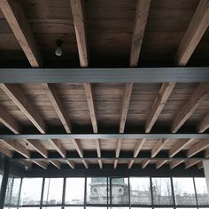 an empty room with large windows and wooden beams on the ceiling is pictured in this image