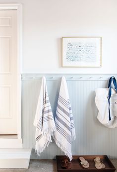 two towels hanging on the wall next to shoes