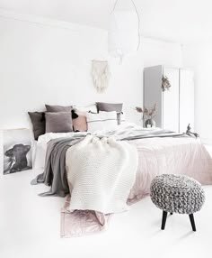 a bedroom with white walls and furniture in it