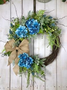 a wreath with blue flowers and greenery