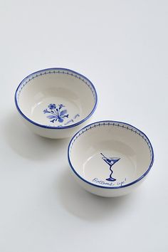 two blue and white bowls sitting on top of a table next to each other in front of a white background